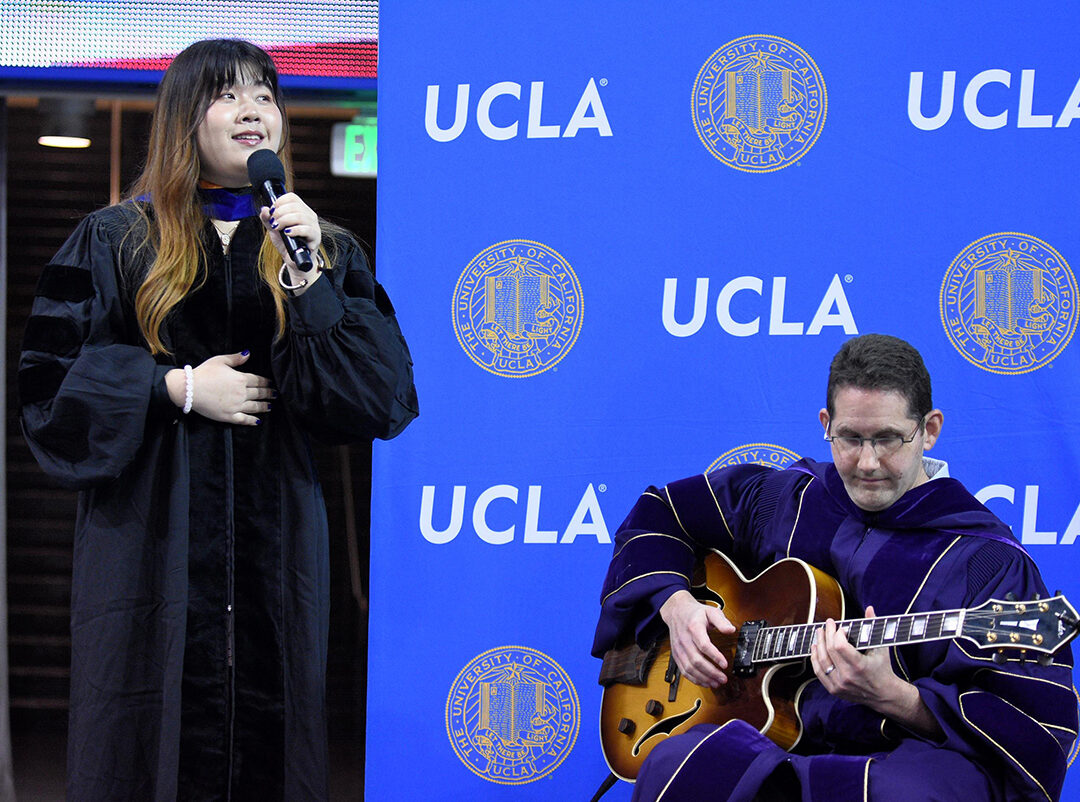 Li (Julie) Zhu performing the national anthem at the graduate commencement, accompanied by Prof. Todd Millstein on guitar